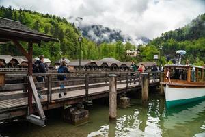 Scenic view on Konigssee Lake with wooden pier with moored touristic ship photo