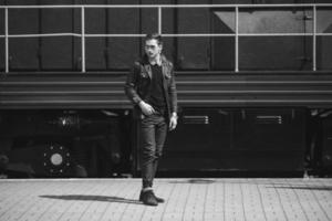 A man dressed in jeans on the background of the train and the station photo