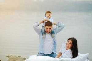 Happy young family relaxing together on the lake photo