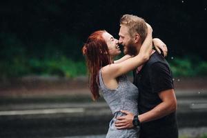 beautiful couple hugging in the rain photo