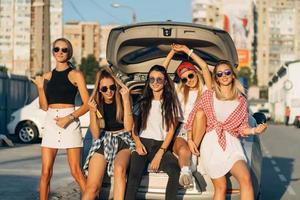 Five young women have fun at the car park. photo