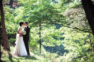 Lovely couple kissing in a wonderful pine forest photo