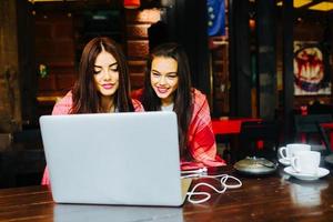 dos chicas viendo algo en la computadora portátil foto