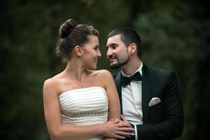 hermosa pareja de bodas sentada en el bosque foto