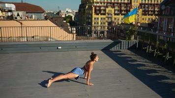 Fit young woman exercises in a sunny outdoor urban space video