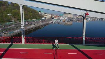 ejercicios de mujer en pista exterior verde y roja cerca de un puente video