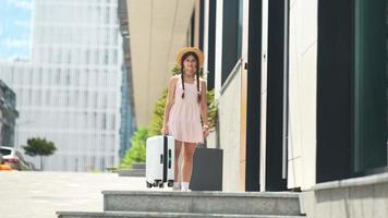 Young woman explores city while carrying luggage video