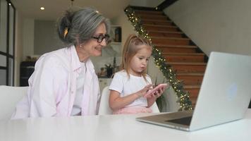 weinig meisje gebruik makend van computer Bij huis met familie video