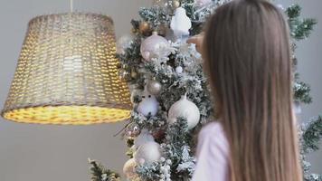 Little girl decorating christmas tree at home video