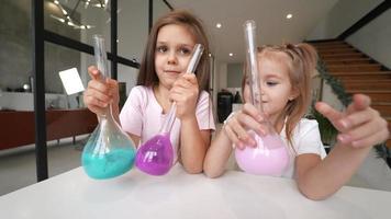 petite fille jouant avec des tubes de chimie à la maison en famille video
