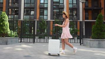 Young woman explores city while carrying luggage video