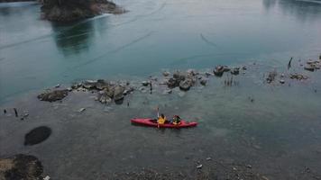 les gens dans la pagaie de kayak orange dans la carrière de roche inondée video