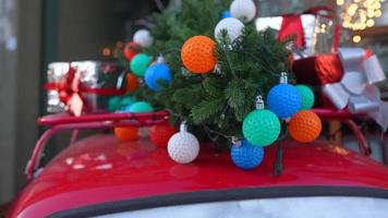 Little red car loaded up with festive holiday decorations and Christmas tree video