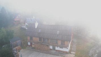 antenne visie van houten cabine structuur en patio Aan mistig ochtend- in de Karpaten bergen in Oekraïne video