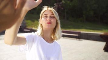 junge blonde frau oder jugendlich schaut auf und high fives person außerhalb der kamera video