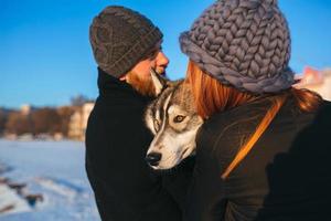 pareja con perro en la nieve foto