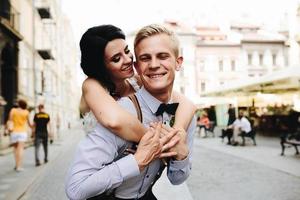 groom carries bride on his back photo