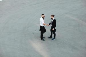 dos hombres de negocios dándose la mano foto