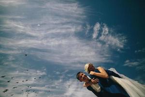 bride and groom  on the background of sky photo