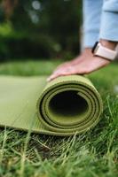 Close-up of woman folding roll fitness after working out in the park photo