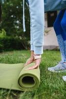 Close-up of woman folding roll fitness after working out in the park photo