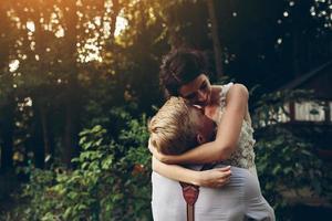 groom holds bride in his arms photo