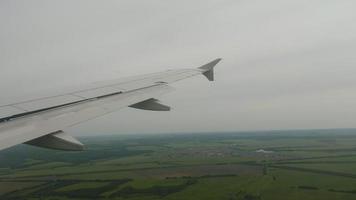 el avión desciende antes de aterrizar en el aeropuerto de kazán, vista desde el ojo de buey del avión. video