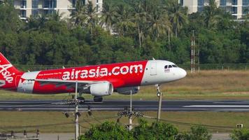 phuket, tailandia 02 de diciembre de 2018 - vista lateral del airbus a320 airasia aterrizando en el aeropuerto de phuket. tráfico de aviación. concepto de turismo y viajes video