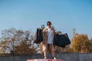 A young woman is standing in a car with bags in her hands photo