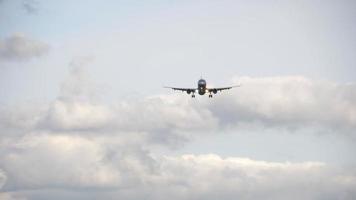 vista inferior, silhueta de um avião a jato de passageiros se aproximando para pousar contra um céu cinza nublado. conceito de turismo e aviação video