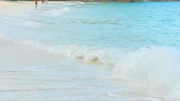 Turquoise rolling wave slamming on the rocks of the coastline, slow motion. Best use for relaxing video