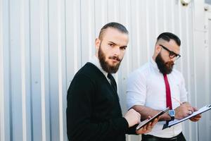 Two bearded businessman looking at something photo