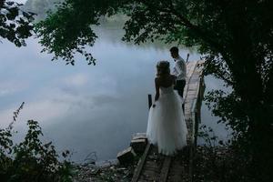 Wedding couple on the old wooden pier photo