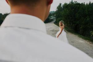 bride leads groom on the road photo