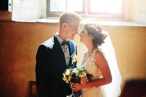 bride and groom on the background of a window. photo