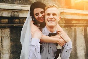 groom carries bride on his back photo