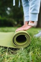 Close-up of woman folding roll fitness after working out in the park photo