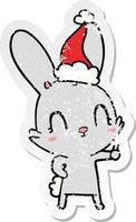 cute distressed sticker cartoon of a rabbit wearing santa hat vector