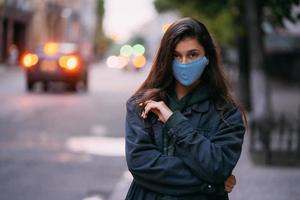 Young woman, person in protective medical sterile mask at empty street photo