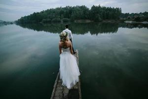 Wedding couple on the old wooden pier photo