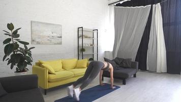 Beautiful young woman doing exercises on the floor at home photo