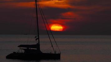 Bright evening landscape. Ocean. Island. Sun and yacht. Sun setting behind a sailing ship video