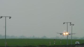 Jet airplane approaching before landing on runway at rainy weather. Airport of Almaty, Kazakhstan video