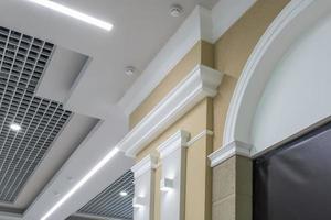 Detail of corner ceiling with intricate crown molding on column with spot light photo