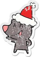 laughing bear distressed sticker cartoon of a wearing santa hat vector