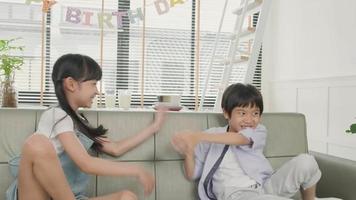 heureuse famille thaïlandaise asiatique, jeunes enfants surpris par le gâteau d'anniversaire, le cadeau, souffler la bougie et célébrer la fête avec les parents et les frères et sœurs ensemble dans le salon, le style de vie de l'événement domestique de bien-être. video