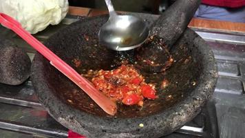 spicy chili sauce added with hot oil from frying chicken meat. typical asia. video