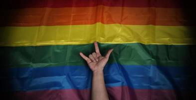 bandera del orgullo lgbtq sobre fondo negro. bandera del arco iris lgbt en mano gay. foto