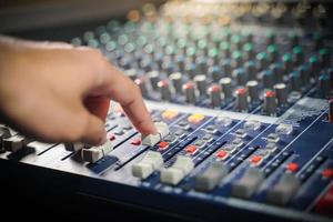 las manos de los hombres controlan la consola de un gran sistema hi-fi.con luz de estilo foto