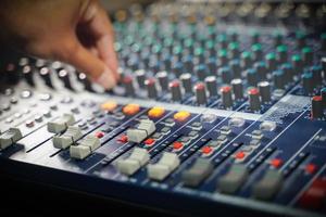 las manos de los hombres controlan la consola de un gran sistema hi-fi.con luz de estilo foto